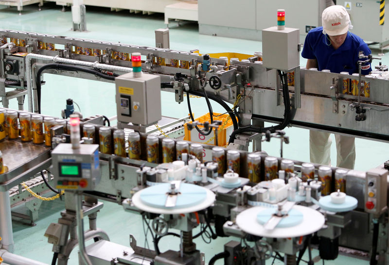 © Reuters. FILE PHOTO - Employee works at a beer production line at Japanese brewer Kirin Holdings' factory in Toride