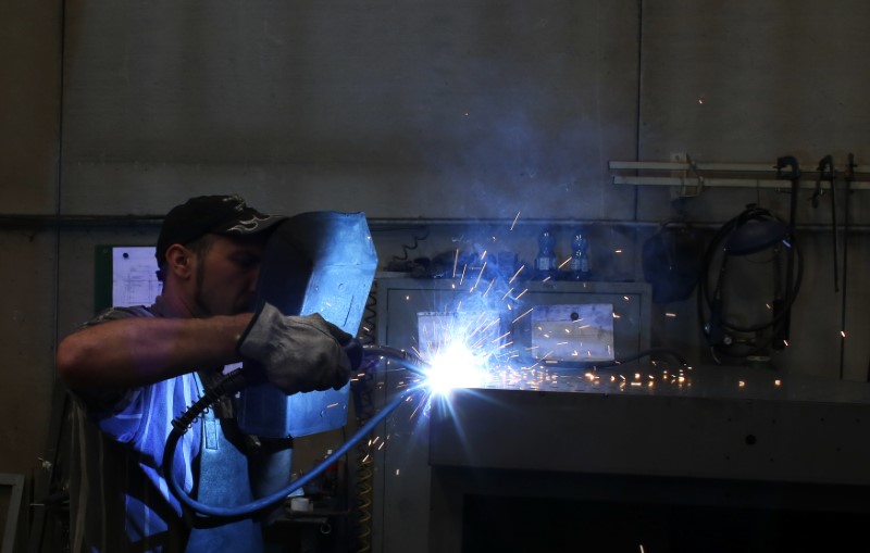 © Reuters. FILE PHOTO: A worker welds in a factory in Gravellona Lomellina