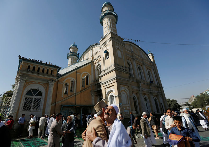 © Reuters. Afghans greet each other outside the Shah-e Doh Shamshira Mosque, on the first day of the Eid al-Adha, in Kabul, Afghanistan