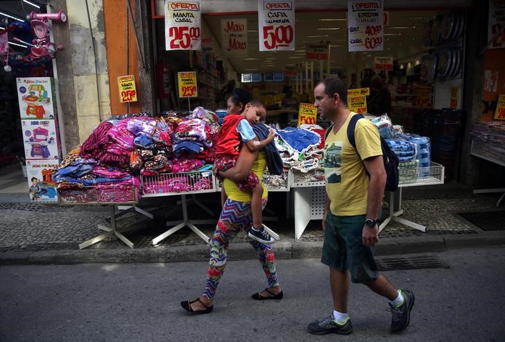 © Reuters. Família caminha em frente a loja no Rio de Janeiro, Brasil