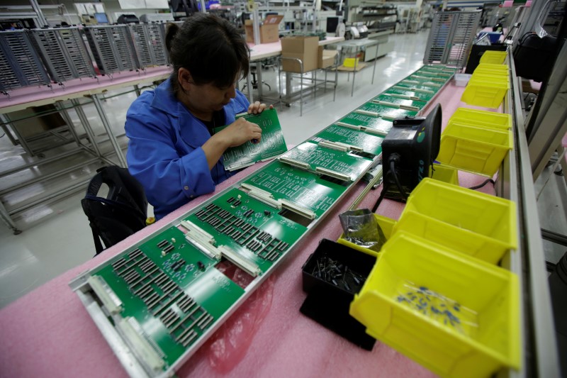 © Reuters. Employee works on printed circuit board at the assembly line of a factory that exports to the U.S., in Ciudad Juarez