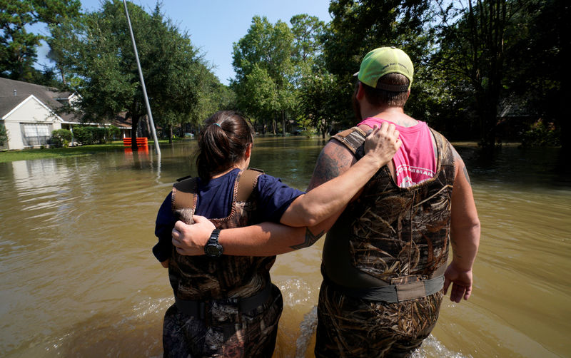 © Reuters. Moradora recebe ajuda em tentativa de retornar para sua casa em Houston após passagem do furacão Harvey