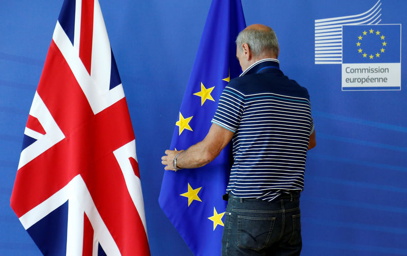 © Reuters. Official adjusts EU flag next to Union Jack flag in Brussels