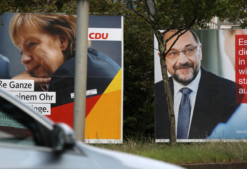 © Reuters. Publicidad electoral con la imagen de la canciller alemana y líder de la CDU, Angela Merkel (izq), y de su rival del SPD, Martin Schulz, en Berlín.