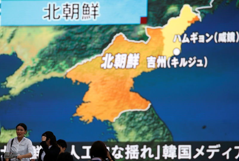 © Reuters. Pessoas passam por tela que mostra reportagem sobre teste nuclear da Coreia do Norte, em Tóquio, Japão