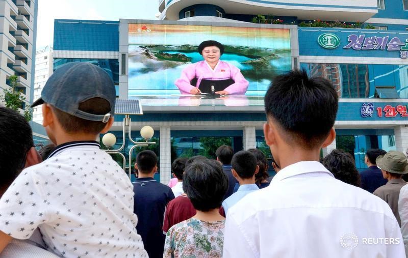 © Reuters. Los norcoreanos ven la noticia que muestra la prueba nuclear de Corea del Norte en pantalla electrónica en Pyongyang