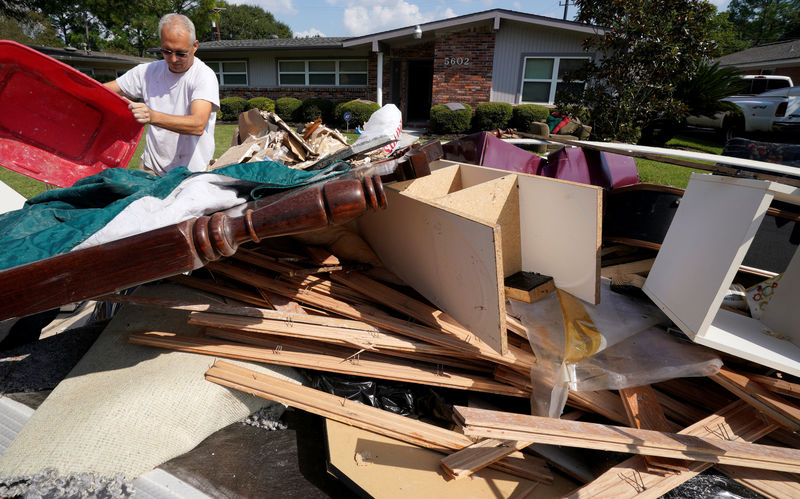 © Reuters. A homeowner adds to a trash pile of Hurricane Harvey flood damage in southwestern Houston