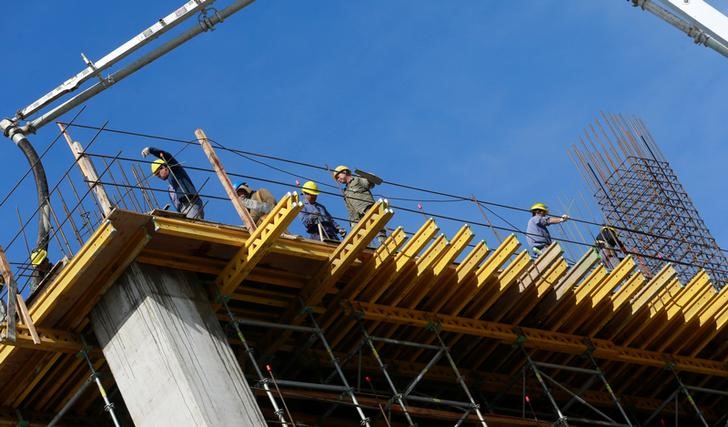 © Reuters. FILE PHOTO - Workers work at a construction site to build an office building and shopping mall in a residential area in Buenos Aires