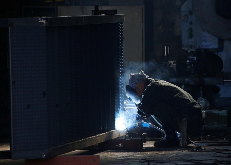 © Reuters. A man works at a factory at the Keihin industrial zone in Kawasaki