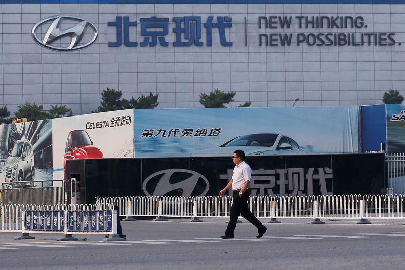 © Reuters. FILE PHOTO: A man walks past a gate of the Hyundai Motor Co plant in Beijing