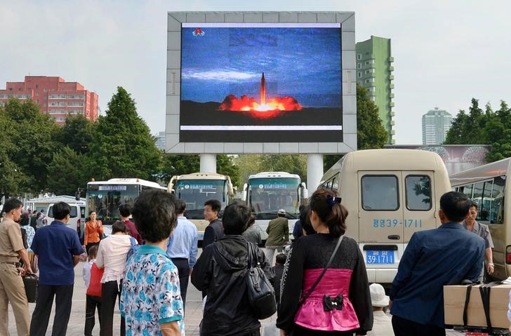 © Reuters. Жители Северной Кореи смотрят репортаж о запуске ракеты  Hwasong-12