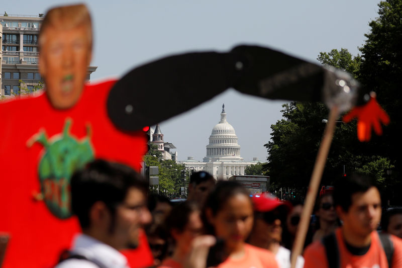 © Reuters. The U.S. Capitol building is seen behind protestors gathered outside the Trump International Hotel to protest President Donald Trump's plan to repeal DACA in Washington