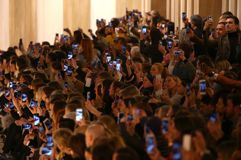 © Reuters. Guests use their mobile phones during the Fendi's Autumn/Winter 2017 women collection during Milan's Fashion Week, in Milan