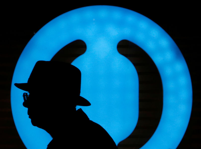 © Reuters. Мужчина на фоне логотипа банка Открытие