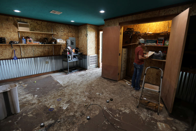 © Reuters. TNT Western Wear owner Tiffany Price sorts through papers in her flood damaged office in the aftermath of tropical storm Harvey in Wharton, Texas