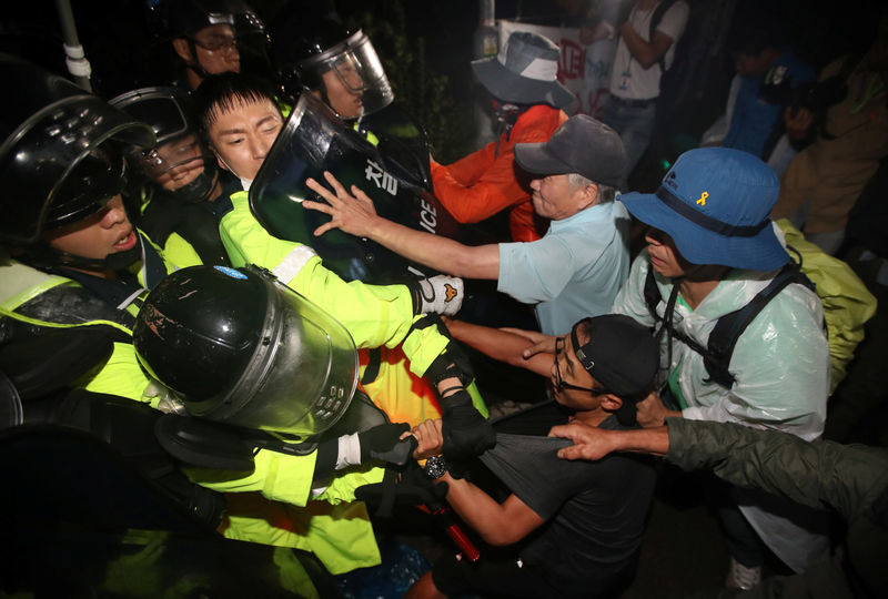 © Reuters. People scuffle with riot policemen during a protest opposing the deployment of a THAAD system in Seongju