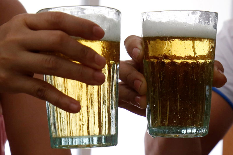 © Reuters. FILE PHOTO: Customers hold glasses of draught beer at a restaurant in Hanoi