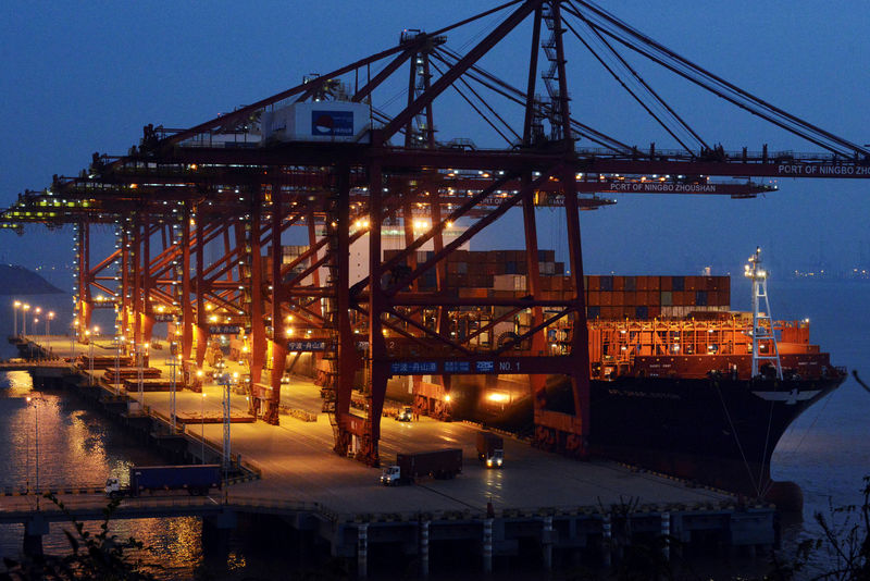 © Reuters. FILE PHOTO: Trucks loaded with cargo containers are seen at Ningbo Zhoushan Port