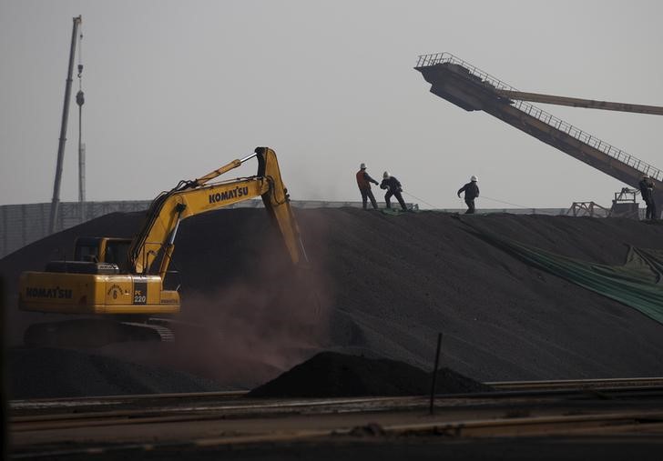 © Reuters. Funcionários trabalham sobre uma pilha de minério de ferro, em uma fábrica de aço, na província chinesa de Hebei