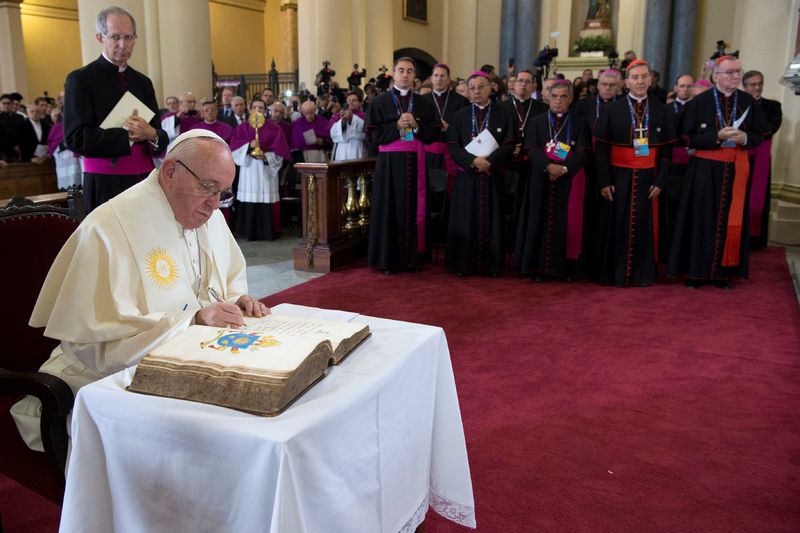 © Reuters. Pope Francis signs a book at the Bogota's cathedral in Bogota