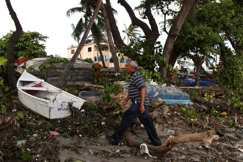 © Reuters. Homem passa diante de barcos após passagem do furacão Irma em Puerto Plata