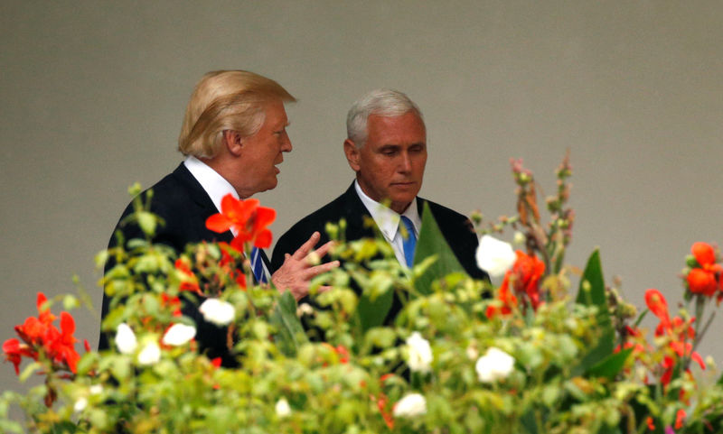 © Reuters. Trump talks with Pence as he departs Washington for North Dakota