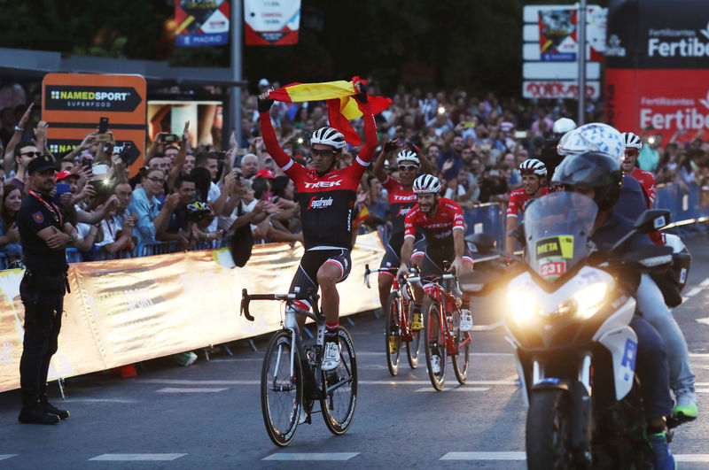 © Reuters. Trek-Segafredo rider Alberto Contador of Spain holds a Spanish flag during a tribute lap with team-mates as he retires after competing in the La Vuelta Tour of Spain cycling race in Madrid