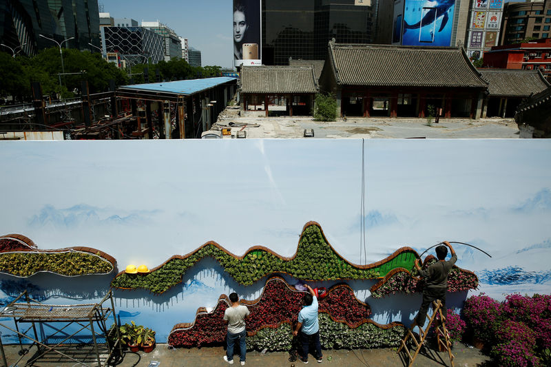 © Reuters. FILE PHOTO: Workers set up a flower display ahead of the the Belt and Road Forum in Beijing