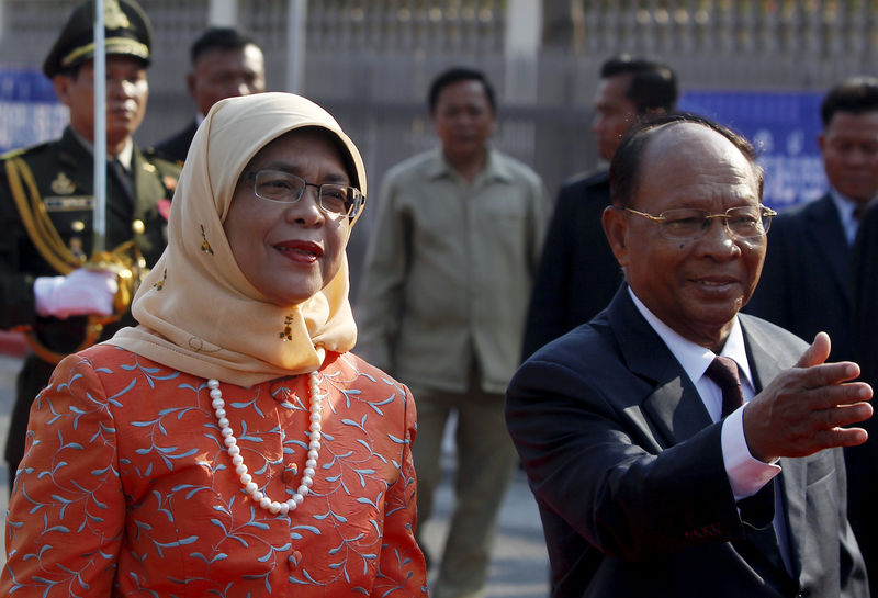 © Reuters. FILE PHOTO: Halimah Yacob inspects the honour guard, accompanied by Heng Samrin during an official welcoming ceremony in front of the Cambodian National Assembly in Phnom Penh