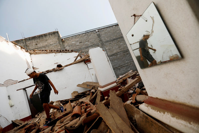 © Reuters. Resident walks on the debris of a house destroyed in an earthquake that struck off the southern coast of Mexico late on Thursday, in Juchitan