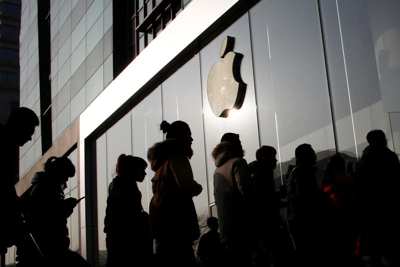 © Reuters. Pessoas fazem fila em loja da Apple pouco antes da abertura em Pequim, China