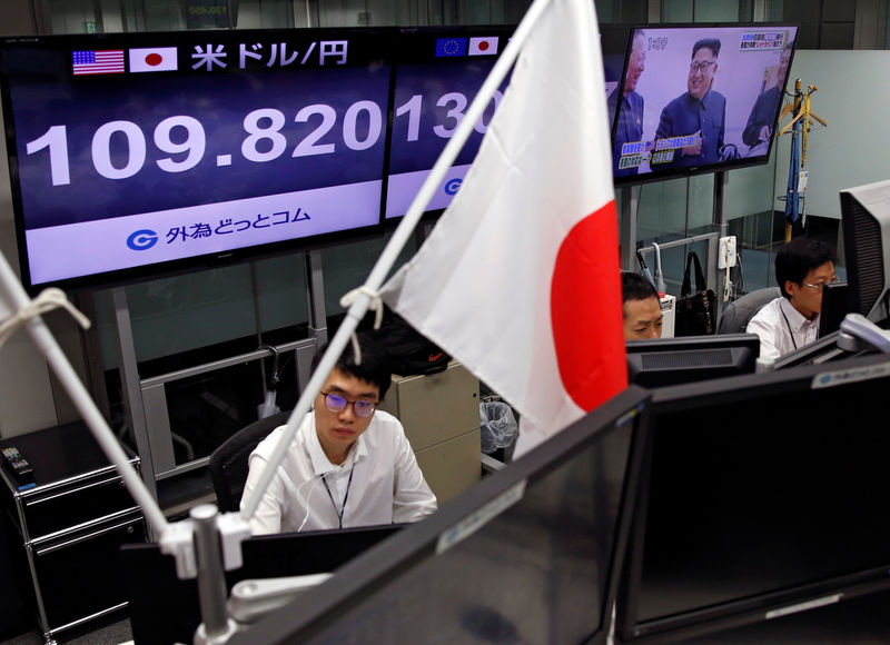 © Reuters. FILE PHOTO - Employees of a foreign exchange trading company work near monitors showing TV news on North Korea's nuclear test and the Japanese yen's exchange rate against the Euro and the U.S. dollar in Tokyo