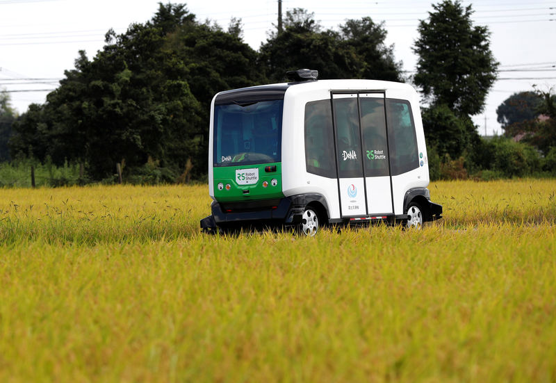© Reuters. Robot Shuttle, a driver-less, self driving bus, drives past between rice stalk during an experimental trial with self-driving bus in a community in Nishikata town