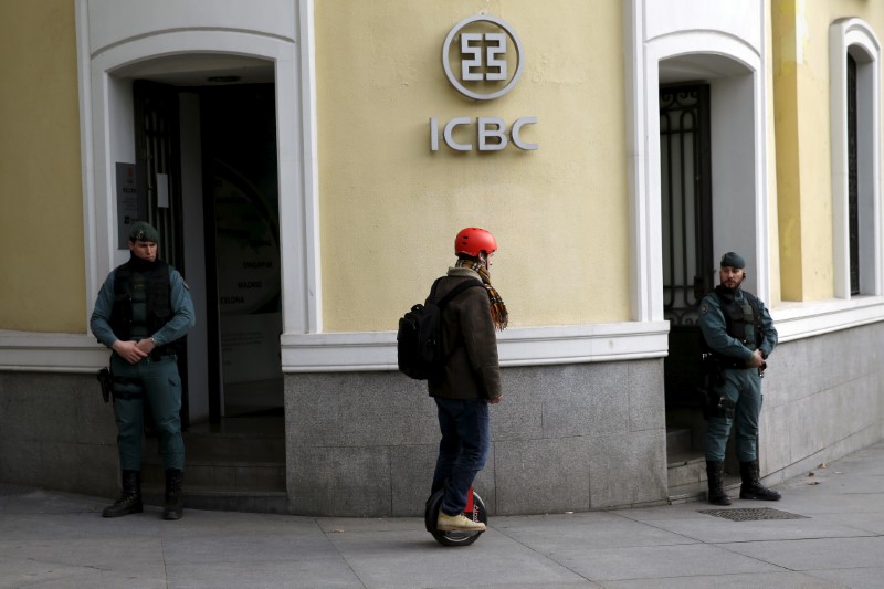 © Reuters. A man rides a segway near Spanish Civil Guards at the headquarters of Industrial and Commercial Bank of China (ICBC) during a raid in Madrid
