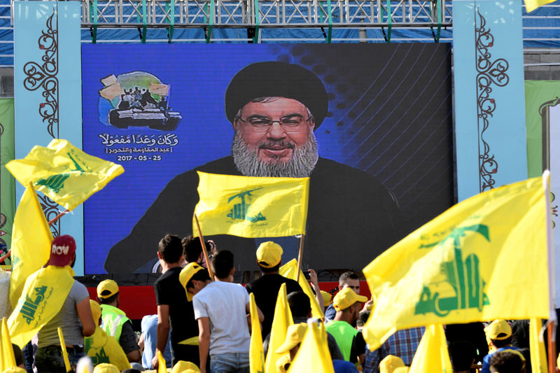 © Reuters. FILE PHOTO:Supporters of Lebanon's Hezbollah leader Sayyed Hassan Nasrallah display Hezbollah and Lebanese flags as he speaks via a screen in Baalbek, Bekaa valley in eastern Lebanon