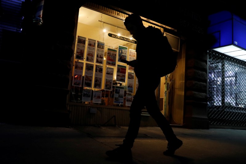 © Reuters. A man walks past a real estate office in Brooklyn, New York