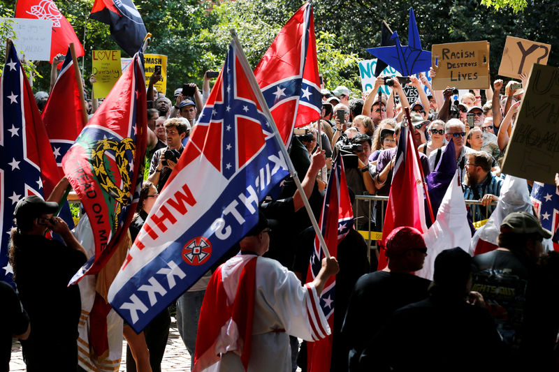 © Reuters. FILE PHOTO: Members of the Ku Klux Klan face counter-protesters as they rally in support of Confederate monuments in Charlottesville Virginia