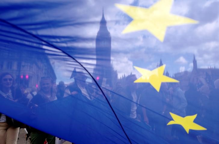 © Reuters. The Houses of Parliament are seen through a European Union flag as demonstrators arrive  in Parliament Square during the anti-Brexit 'People's March for Europe', in central London