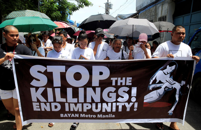 © Reuters. FILE PHOTO: Relatives and loved ones of Leover Miranda hold a streamer calling to stop the continuing rise of killings uring a funeral march at the north cemetery in metro Manila