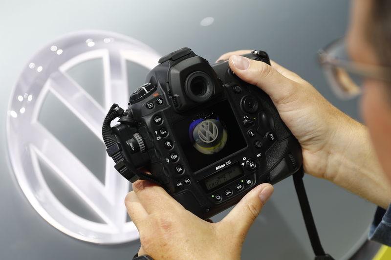 © Reuters. A photographer takes a picture of a Volkswagen logo before the opening of the Frankfurt Motor Show