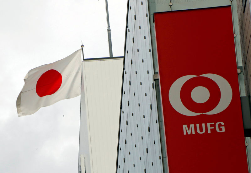 © Reuters. Japan's national flag is seen behind the logo of  Mitsubishi UFJ Financial Group Inc (MUFG) at its bank branch in Tokyo