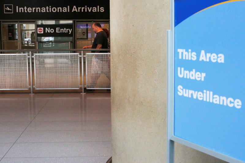 © Reuters. A sign warns of surveillance at the International Arrival area at Logan Airport