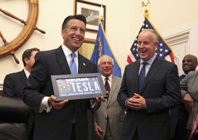 © Reuters. Nevada Governor Sandoval welcomes Tesla VP of Business Development O'Connell to the state by presenting him with a vanity license plate, in Carson City, Nevada