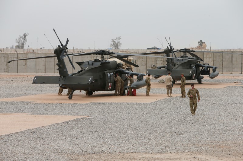 © Reuters. U.S army soldiers stand next to helicopters at the Qayyarah West Airfield