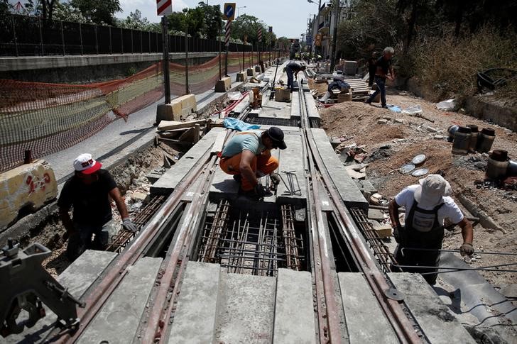 © Reuters. Labourers work on the construction of a tram railway track in Piraeus, near Athens