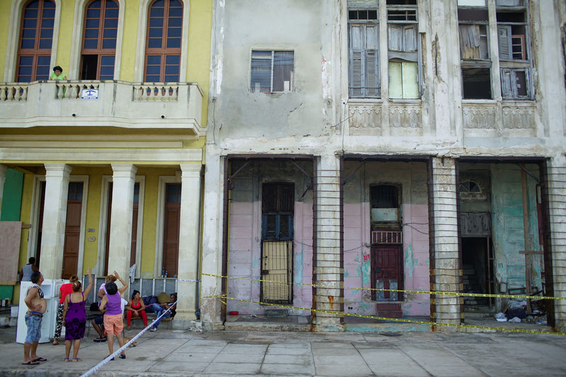 © Reuters. A family stay outside their home due to the risk of collapsing at the seafront Malecon after the passage of Hurricane Irma in Havana, Cuba