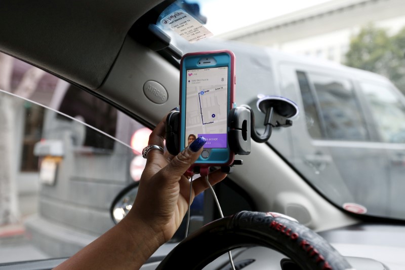 © Reuters. FILE PHOTO - Maya Jackson a Lyft driver from Sacramento responds to a ride request on her smartphone during a photo opportunity in San Francisco