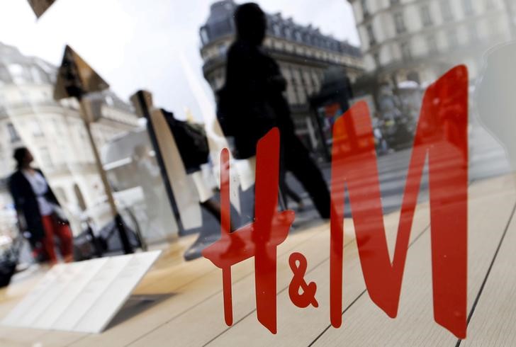 © Reuters. File photo shows people walking past the window of a H&M store in Paris