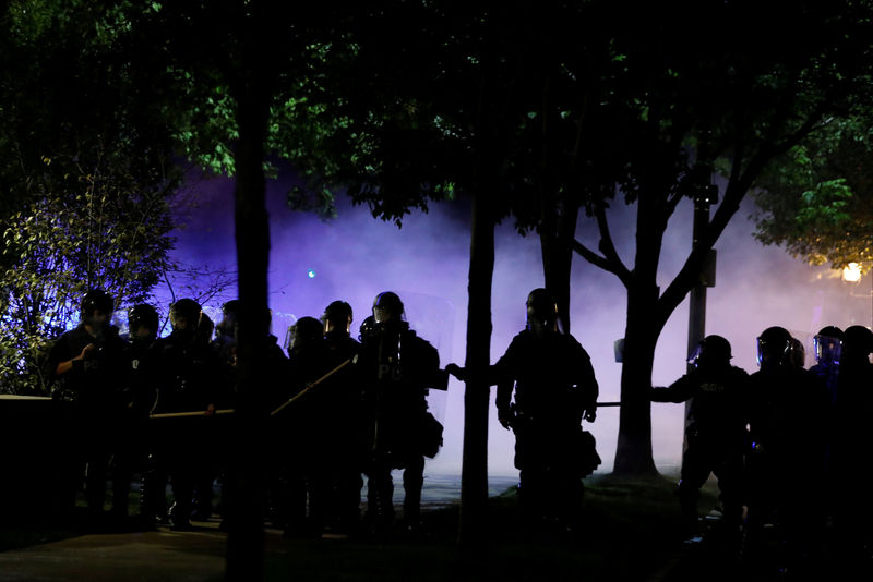 © Reuters. Law enforcement officials walk down a residential street after firing tear gas at protesters following acquittal of Stockley in St Louis