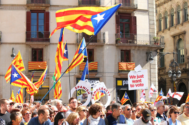 © Reuters. People raise up giant handcuffs and banners during the Catalan mayors protest in Barcelona